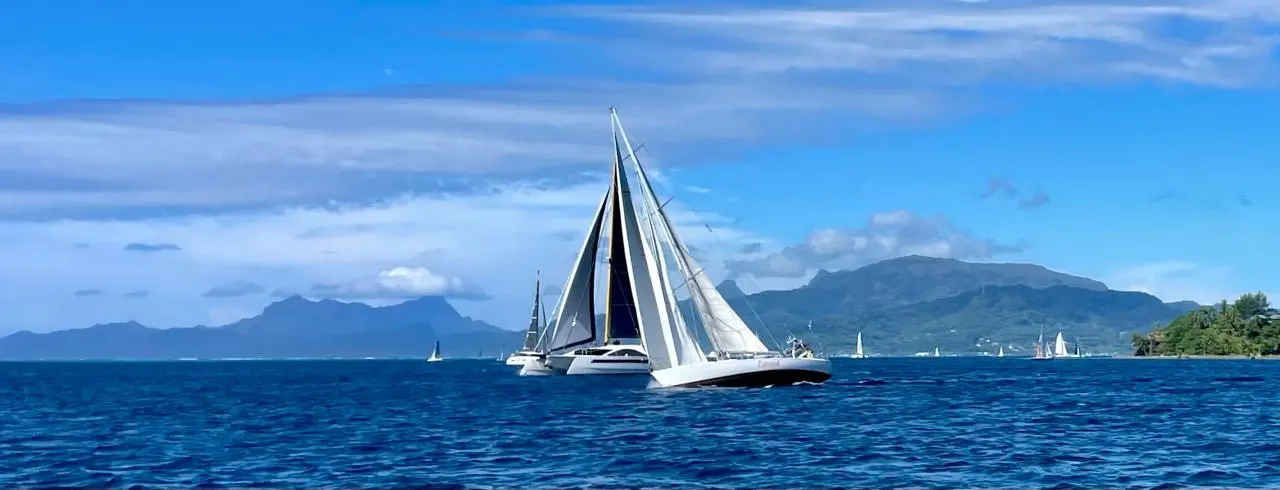 One Cat naviguant sous voile devant les montagnes de Tahiti